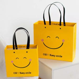 China ISO Shock Resistant Smile Face Kraft Paper Bags Yellow Square Bottom Paper Bag wholesale